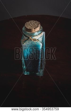 Fancy Bottle With Blue Bath Salts For Relaxing Spa Treatments With Wooden Background