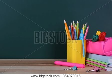 Stationery On Wooden Table Near Chalkboard, Space For Text. Doing Homework
