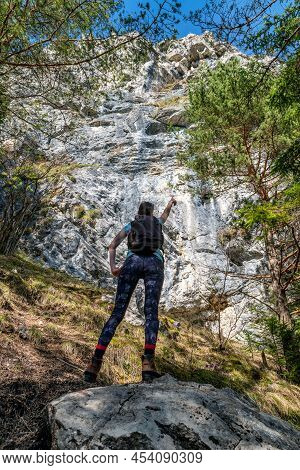 Hiker Girl With Backpack Showing On Large Rock Formation Called Cerenova Skala In Slovakia.