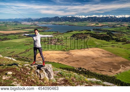 Happy Hiker Woman On Top Of The Hill With Beautiful Spring Landscape At Background. Lake Liptovska M