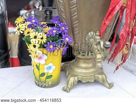 Antique Brass Samovar And Cachepot With Yellow And Purple Summer Flowers.