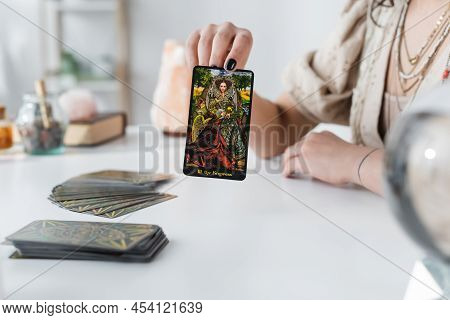 Kyiv, Ukraine - February 23, 2022: Cropped View Of Soothsayer Holding Tarot Card At Home