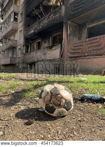 Courtyard Of A Destroyed Multi-storey Building After An Airstrike. Soccer Ball On The Background Of