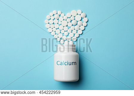 Calcium Supplement. Bottles With Pills On Turquoise Background, Flat Lay
