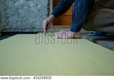 The Master Cuts Expanded Polystyrene On A Floor, Installation And Warming Of A Floor In A Room.