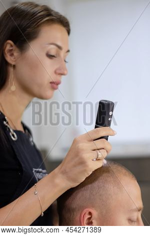 Trichoscope Examination Of Hair, Scalp And Hair Follicles Of A Young Man. Copy Space. The Head Of A 