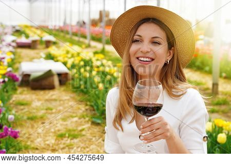 Portrait Of Happy Young Woman Holding Wine Glass Looking To The Side And Smiling. Copy Space.