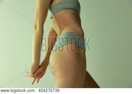 Side View Of Cropped Image Of Female Body, Bottocks In Underwear Isolated Over Grey Studio Backgroun