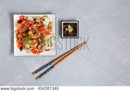 Top View Of A Plate With A Poke Salad Of Seafood, Rice And Vegetables, Avocado And Chia Seeds With S