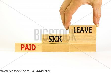 Paid Sick Leave Symbol. Concept Words Paid Sick Leave On Wooden Blocks. Doctor Hand. Beautiful White