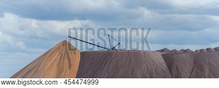 Giant Spreader Or Absetzer Machinery. A Large Dumper On A Landfill With Potash Ore. Extracting And M
