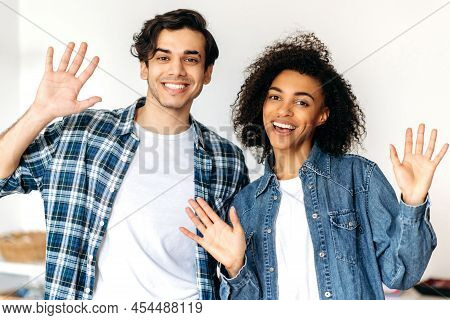 Joyful Guy And Girl Posing At Camera. Portrait Of Friendly Joyful Young Multiracial Couple Standing 