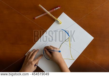 Childrens Hand With Pencil Draws The Heartl