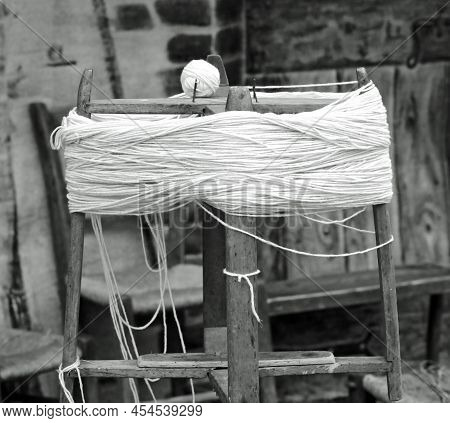 Antique Wooden Spinning Wheel Or Swift With The Skein Of Wool Below And The Ball Of Yarn Above With 