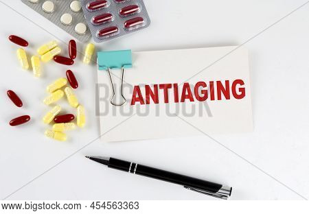 Antiging Text Written In Card With Pills. Medical Concept.