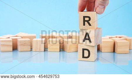 Hand Holding Wood Cube Block With Rad Text. The Inscription On The Cubes Is Reflected From The Surfa