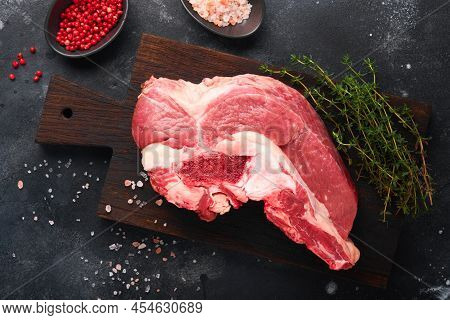 Raw Beef Meat. Rough Piece Of Meat On Bone For Roast Or Soup With Salt, Pepper, Thyme And Rosemary O
