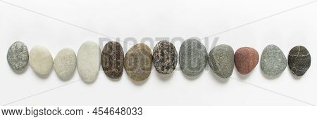Wide Banner With Many Rounded Raden Nature Raw Pebble Stones On White Background.