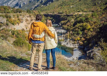 Montenegro. Happy Couple Man And Woman Tourists On The Background Of Clean Clear Turquoise Water Of 