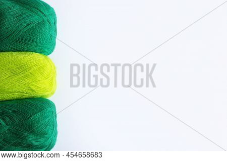 Green Yarn Threads On A White Background For Knitting. Flat Lay