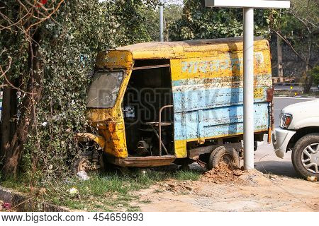 Delhi, India - February 25, 2022: Abandoned And Broken Auto Rickshaw In A City Street.