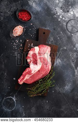 Raw Beef Meat. Rough Piece Of Meat On Bone For Roast Or Soup With Salt, Pepper, Thyme And Rosemary O
