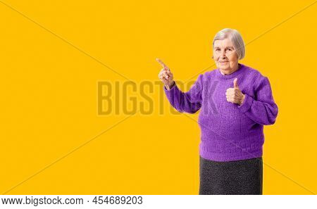 Cheerful Octogenarian Woman Showing On Empty Place For Copy Space. Background For Your Promo Or Adve