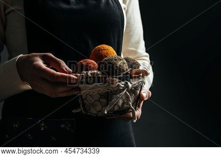 Swiss Belper Knolle Cheese. Woman Hands Hold Basket With Belper Cheese On A Dark Background.