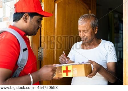 Focus On Customer, Senior Person Receiving Online Orderd Medicine Box From Delivery Boy After Singin