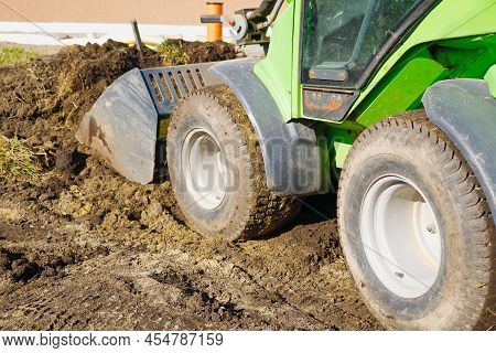 Traktor On The Field. Mini Traktor Landscaping At Home Backyard