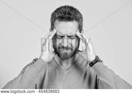 Mature Man With Beard Suffer From Headahce On Grey Background, Health