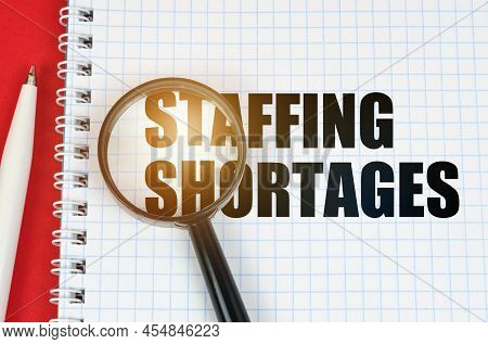 Business And Finance Concept. On The Red Surface Is A Pen, A Notepad With The Inscription - Staffing