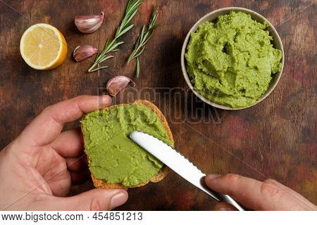 Avocado Toast. Mans Hands Spreading Avocado Paste On A Slice Of Bread. Healthy Food Concept, Top Vie