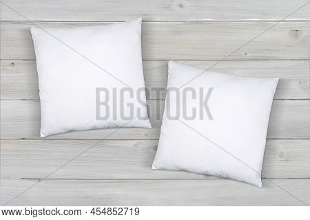 Two White Throw Pillows Taking A Nap On A Modern Gray Wood Background