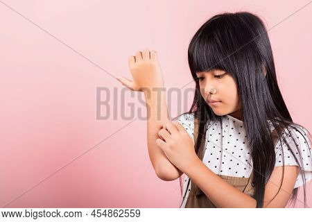 Asian Little Kid 10 Years Old Scratching Itch Arm From A Mosquito Bite At Studio Shot Isolated On Pi