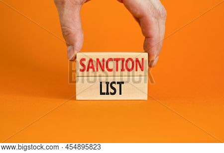 Sanction List Symbol. Wooden Blocks With Concept Words Sanction List On Beautiful Orange Background.