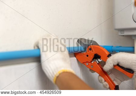 Plumber Installing Floating Pipeline On The Wall In The Old Bathroom.
