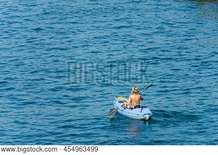 Tellaro, Liguria, Italy - July 21, 2019: Mature Woman Aboard A Blue Kayak, Paddling In The Blue Medi