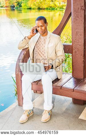 Business Man Working Outside. Dressing In Cream Blazer, Collarless Sweater, White Pants, Sneakers, A