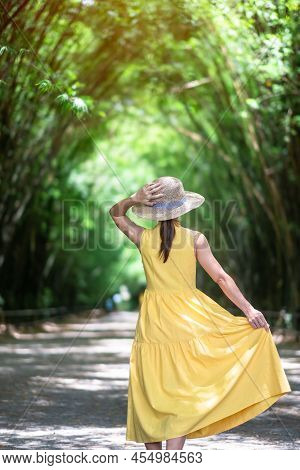 Asian Woman In Yellow Dress And Hat Traveling At Green Bamboo Tunnel, Happy Traveler Walking Chulabh