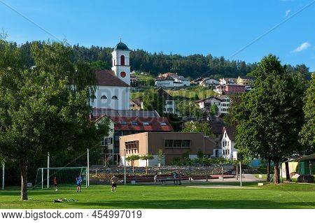Mauren, Liechtenstein - May 20, 2022: Town Of Mauren With Its Sportsyard, Church And Houses.