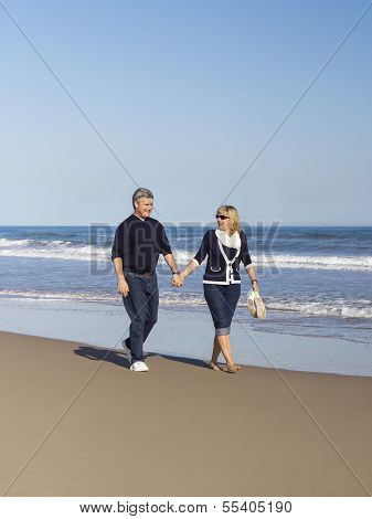Sportive Mature Couple Walking Along The Beach