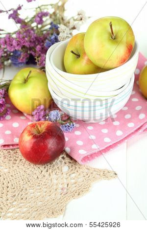 Juicy apples on plate on white wooden table