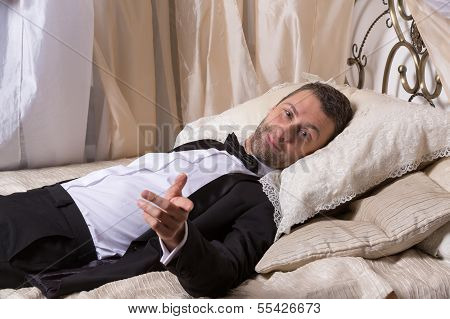 Elegant Playboy Reclining On A Bed