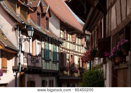 Street with half-timbered medieval houses in Eguisheim village along the famous wine route in Alsace