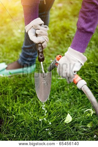 Photo Of Woman Cleaning Garden Tool With Hosepipe