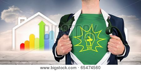 Businessman opening shirt in superhero style against diagram of a house with energy rating chart