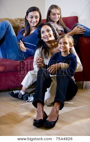 Madre con tre figli di relax sul divano del salotto