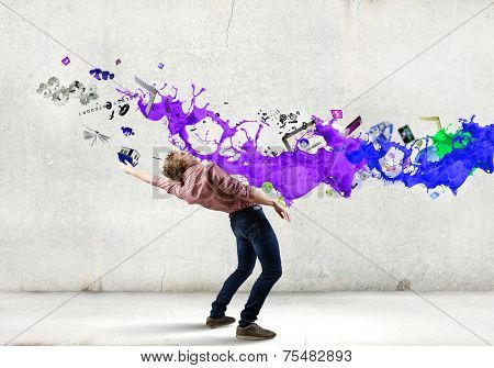Young guy in casual evading from colorful splashes