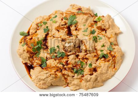 Traditional homemade Ottoman circassian chicken, shredded meat in walnut sauce, drizzled with walnut oil coloured with paprika